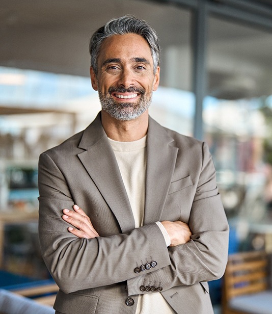 Man at work smiling confidently with his dentures in Denton