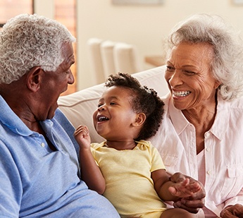 Grandparents smiling and having fun with their grandchild