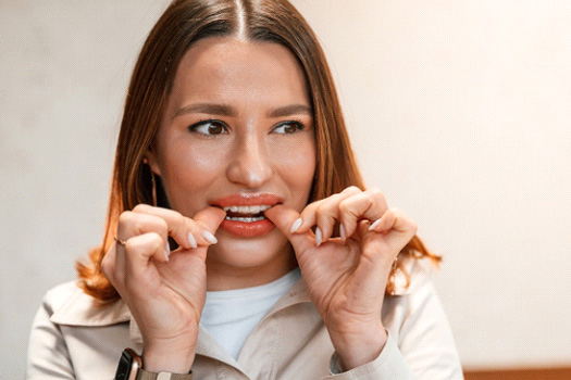 Patient putting on clear aligner in treatment room