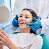 Woman looking at her smile at the dentist